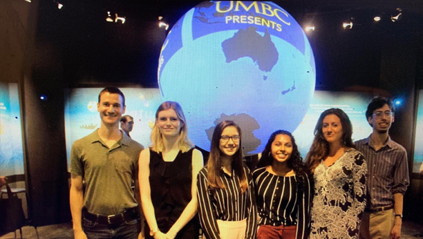 A group of students in front of a globe