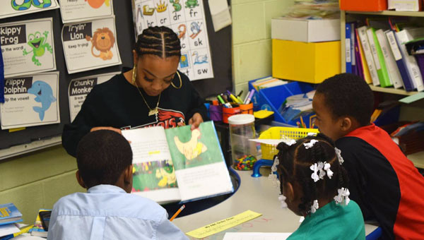 A teacher is reading to first graders