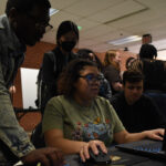 Several young students playing a game demo developed by the UMBC Game Club