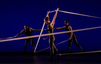 Three people performing a dance with ribbons