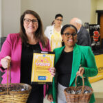 Two faculty members smiling together at the opening of the undergraduate research and creative achievement day.