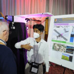 A young undergraduate researcher presenting his research to the public