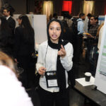 A young undergraduate researcher presenting her research to the public