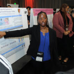 A young undergraduate researcher presenting her research to the public