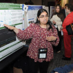 A young undergraduate researcher presenting her research to the public