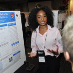 A young undergraduate researcher presenting her research to the public