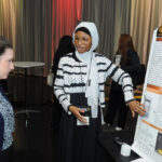 A young undergraduate researcher presenting her research to the public