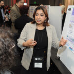 A young undergraduate researcher presenting her research to the public