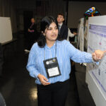 A young undergraduate researcher presenting her research to the public