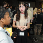 A young undergraduate researcher presenting her research to the public
