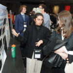 A young undergraduate researcher presenting her research to the public