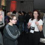 A young undergraduate researcher presenting her research to the public