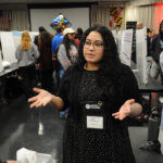 A young undergraduate researcher presenting her research to the public