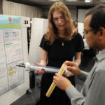 A young undergraduate researcher presenting her research to the public