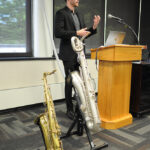 A young undergraduate researcher presenting his research to the public