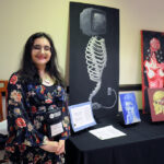 A young undergraduate researcher presenting her research to the public