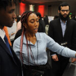 A young undergraduate researcher presenting her research to the public
