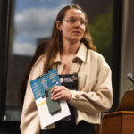 A staff member introducing the next presenter to a group of students