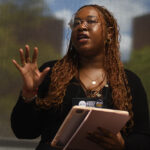 A young undergraduate researcher presenting her research to the public