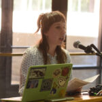 A young undergraduate researcher presenting her research to the public