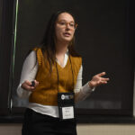 A young undergraduate researcher presenting her research to the public